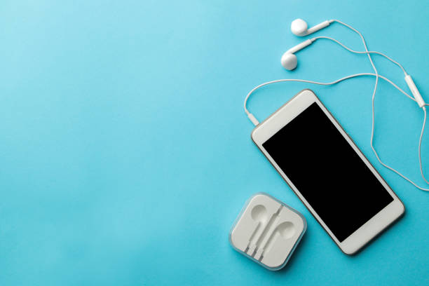 istock Smartphone. White phone and headphones on a bright light blue background. top view. space for text 1448912605