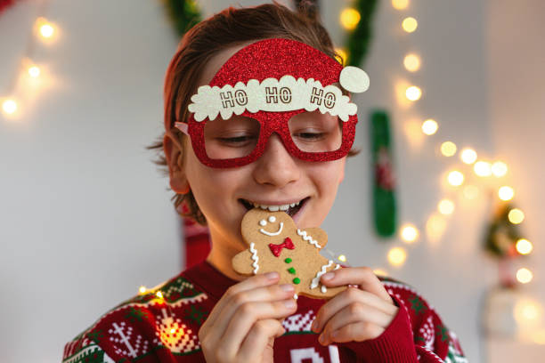 istock Cute kid boy in Christmas outfit eating gingerbread man 1448914687
