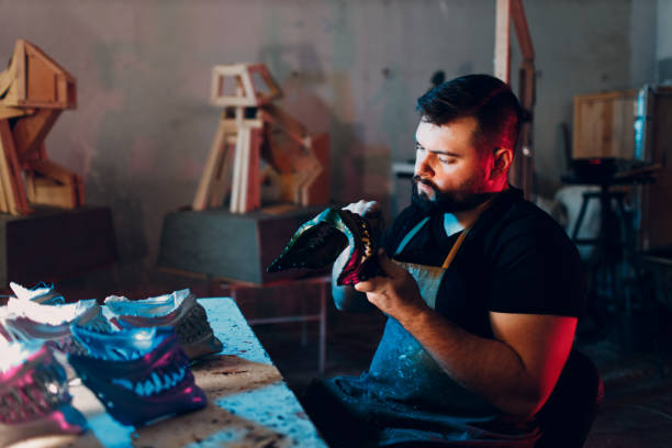 istock Artisan craftsman create mask based on plaster cast. Gypsum mold and plastic mask sculpting 1448914785