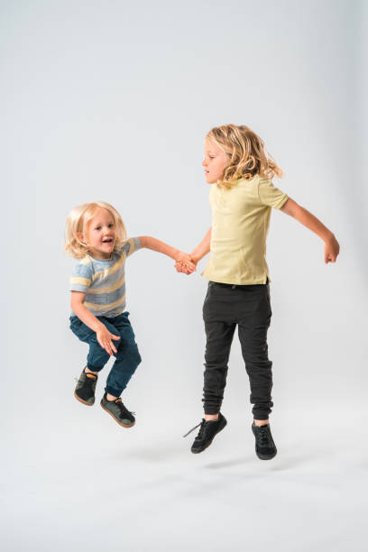istock Two Blonde Boys Leaping From the Ground 1448914803