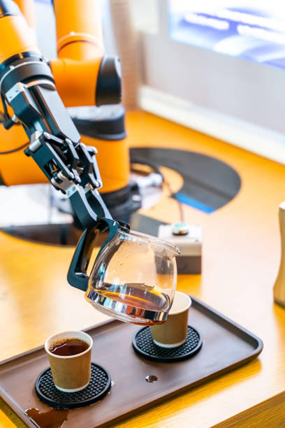 Robotic arm preparing coffee in coffee machine stock photo