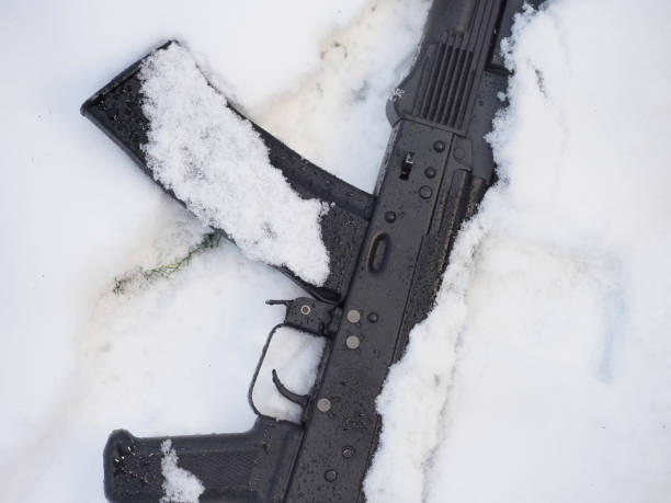 istock Black metal gun machine in snow 1448921025