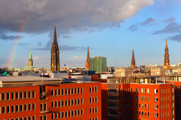 Cathedral spires over the roofs . Hamburg architecture with houses and cathedral . Rainbow over the Hamburg
