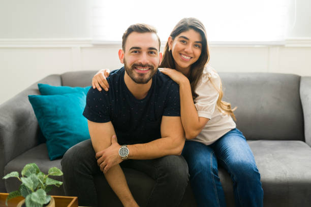istock Happy couple resting at the sofa and smiling 1448933242