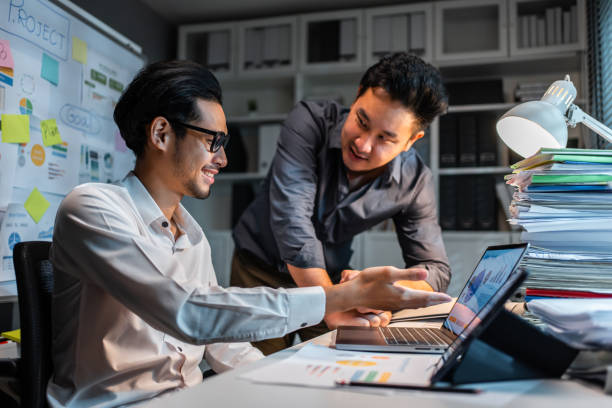 istock Asian handsome two businessman using laptop computer working in office. Attractive male employee brainstorm and meeting as team, plan and discuss project in workplace. Corporate of modern colleagues. 1448935788