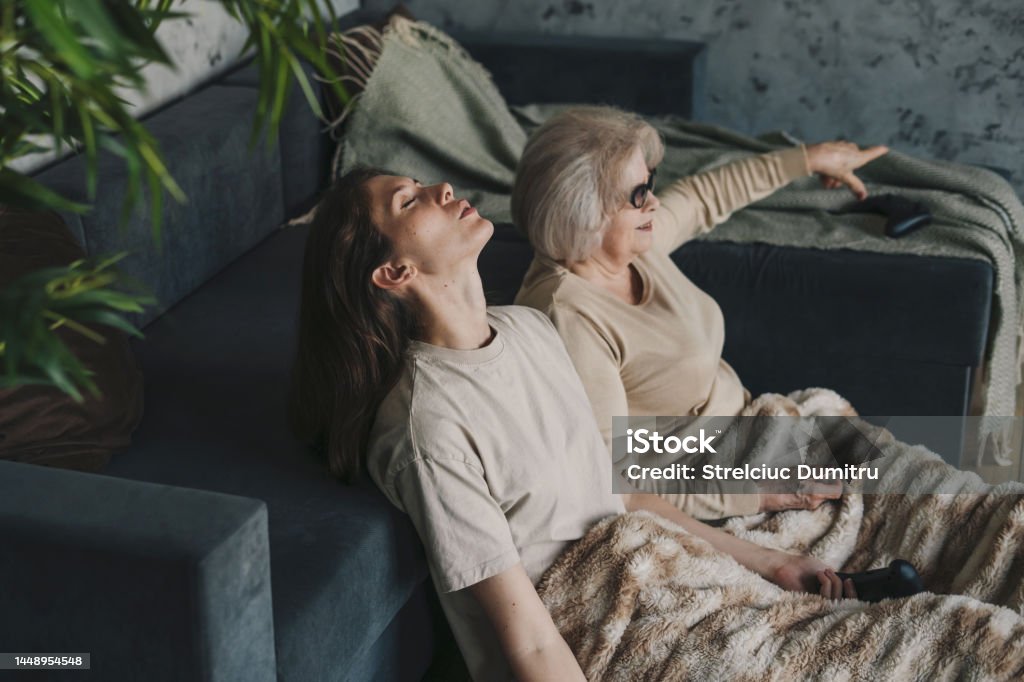 Old woman playing playstation having fun like crazy together with her adult daughter. Entertainment concept with playstation. The concept of having fun together 30-34 Years Stock Photo
