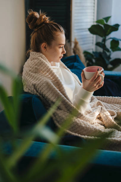 istock Side view of a pretty ginger woman drinking coffee while spending time at home resting from the daily routine. Positive emotion. Happy lifestyle. Cozy apartment. 1448955930