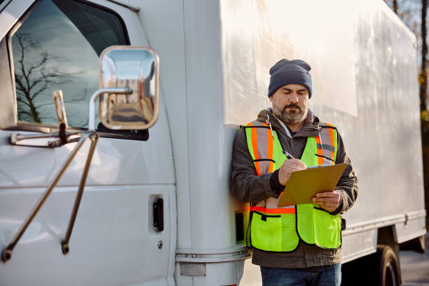 istock Truck driver going through shipment list on parking lot before the ride. 1448958307