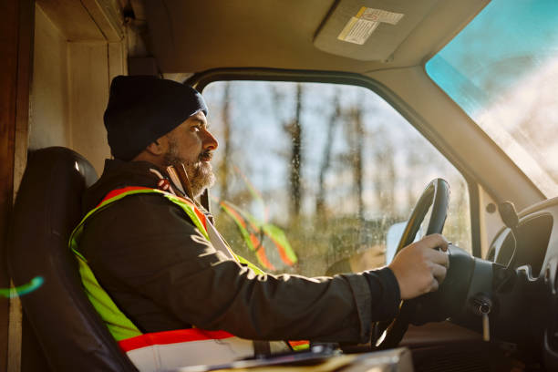 istock Side view of courier driving delivery van on the road. 1448958374