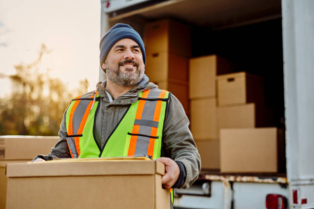 istock Happy worker unloading packages from delivery van and looking away, 1448959024