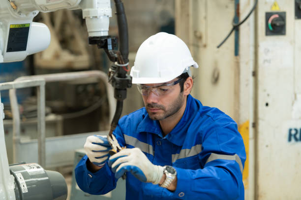 istock Young male engineers with experience are maintaining and testing the functionality of welding robots 1448961385