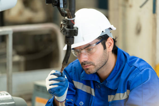 istock Young male engineers with experience are maintaining and testing the functionality of welding robots 1448961392