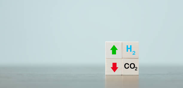Free Carbon, alternative energy and global climate change concepts. Hand flipping wooden cube blocks with CO2 Carbon dioxide, change to H2 Hydrogen text on table background. Sustainable car energy. stock photo