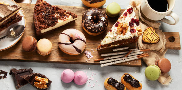 istock Table with various cakes, cookies, donuts and coffe cups on light background. 1448966099