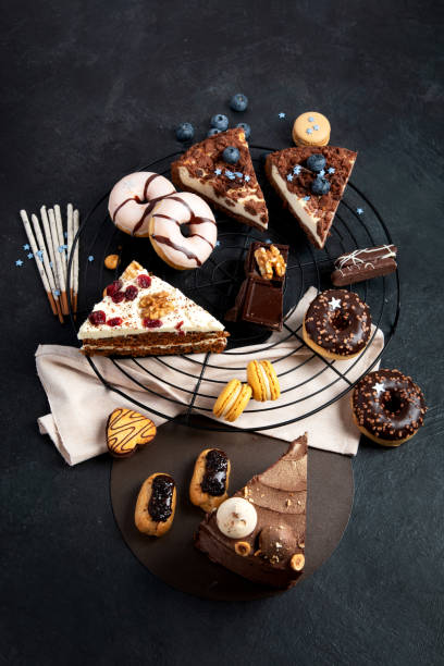 istock Table with various cookies, donuts, cakes, cheesecakes on dark background. 1448966121