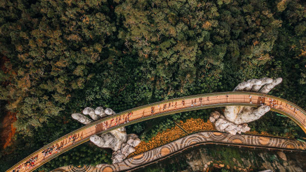 Golden Bridge, Ba Na Hill, Da Nang, Vietnam Da Nang city, Vietnam - November 18, 2022:Tourists walk on the Golden Bridge in Ba Na Hills, supported by a pair of giant hands. The bridge located 1,400 meters above sea level with hill scenery bridge hand stock pictures, royalty-free photos & images