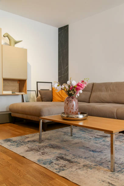 istock Grey comfortable sofa with mustard yellow cushion and coffee table with flower vase in the living room, modern living concept. 1448978960