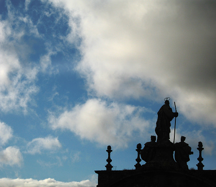 Santiago de Compostela cathedral decoration seen from the stone rooftop. Sculptures, decoration, pinnacles, dramatic sky. Galicia, Spain.