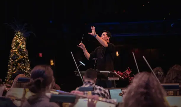 Photo of Middle-aged male conductor directing rehearsal of Christmas concert