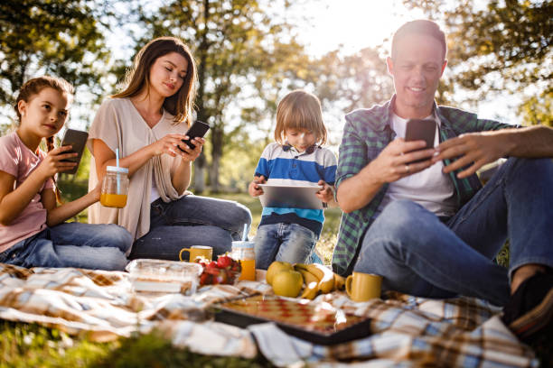 istock Family using wireless technology on picnic in nature. 1448984946