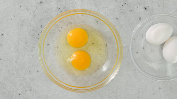 istock Raw eggs in a glass bowls, close-up on a light grey background 1448987861