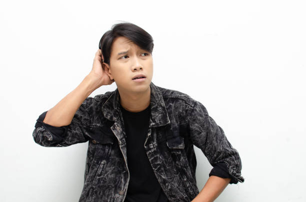 istock A thoughtful, perplexed Asian man considers whether to select something isolated against a white background. man feeling uncertain and unsure. 1448988095
