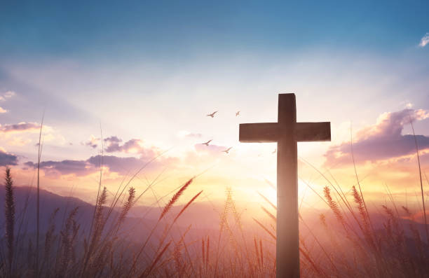 istock Christian wooden cross on sunset background. 1448989157