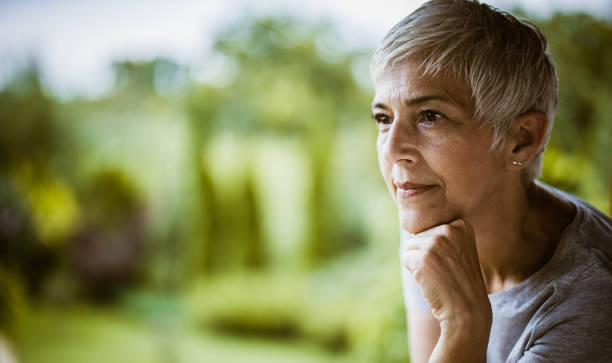 istock Senior woman day dreaming in nature. 1448990125