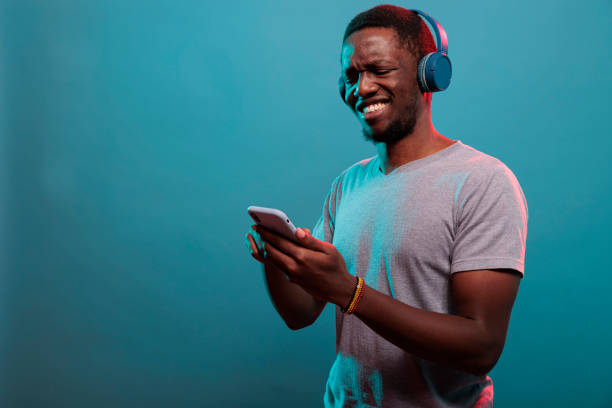 istock Millennial guy using smartphone and enjoying music on headphones 1448991766