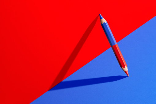 Classic red and blue pencil with shadow in red and blue corner.