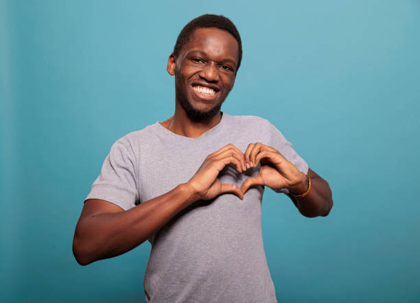 istock Young adult doing heart shaped sign with hands in studio 1448992830