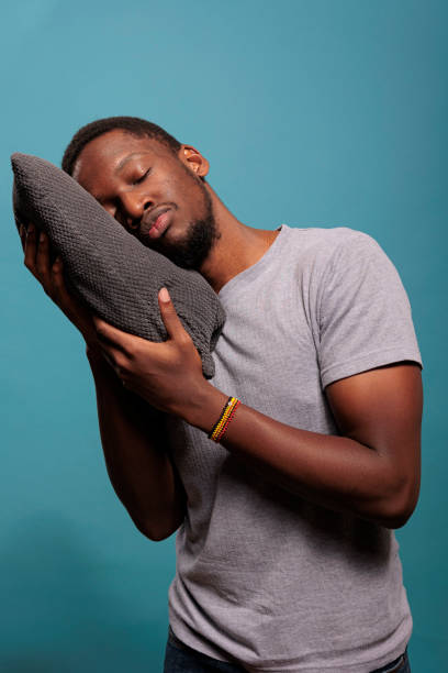 istock Young adul holding pillow to take a nap in studio 1448993023