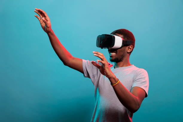 istock Cheerful model raising hands and playing with futuristic vr glasses 1448994128