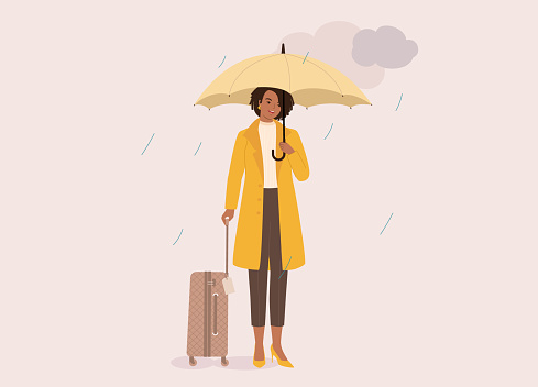 One Smiling Black Young Woman In Yellow Coat Holding Luggage And Umbrella On A Rainy Day With Dark Clouds. Isolated On Color Background.