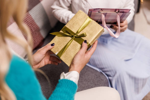 istock Young woman holding a gold colored Christmas gift box 1448995241