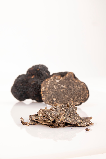 Cut truffle with detail on flakes on a white background