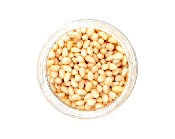 istock Prepared cedar pine nuts in round glass can isolated on white, top view 1448997216