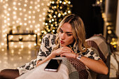 Young woman waiting to receive a text message from a loved one via smart phone
