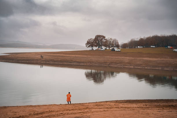 man fishing by the lake stock photo