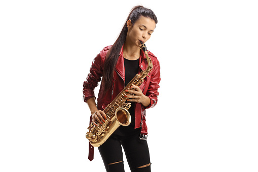 Beautiful young woman playing a saxophone isolated on white background