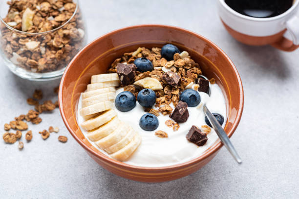 Yogurt with granola, banana, blueberries and dark chocolate stock photo
