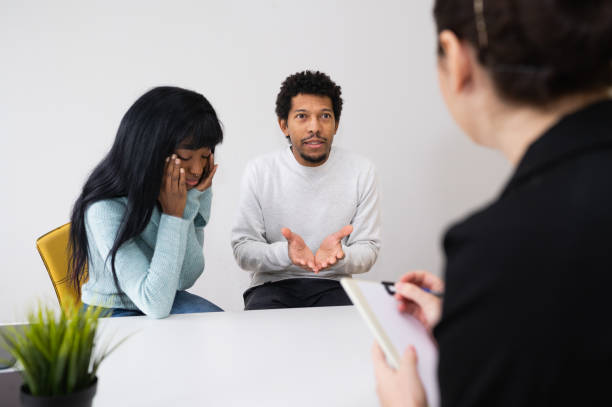coppia nera infelice che parla con uno psicologo professionista durante una terapia mentale - violence married therapy solution foto e immagini stock