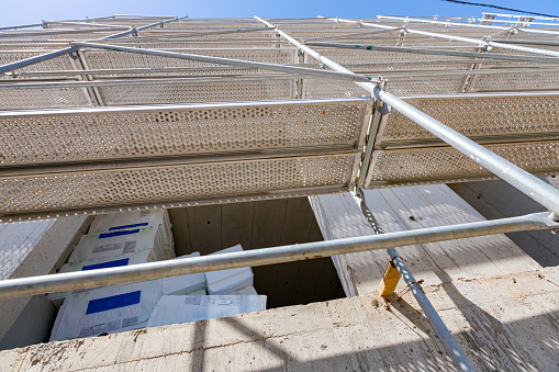 Bottom shot of thermal insulation material on the terrace of unfinished edifice with scaffold