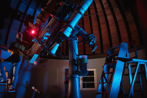 istock Astronomer with a big astronomical telescope in observatory doing science research of space and celestial objects. 1449007582