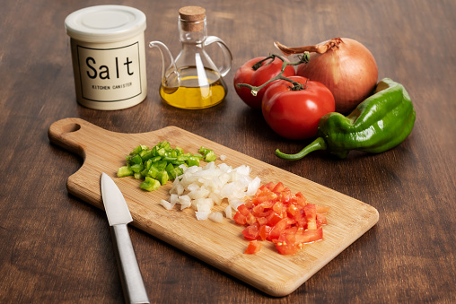 Tomatoes, peppers, onion, salt and oil, necessary ingredients to prepare a paella.