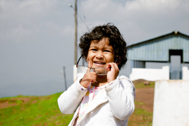 Healthy African playful child posing,with finger on cheeks.