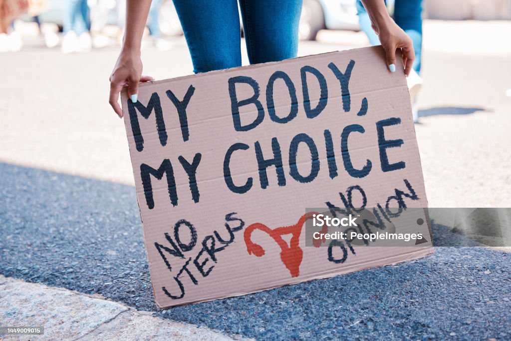 Protest, woman and human rights poster for abortion activism choice, decision and discrimination. Feminist, politics and pregnancy termination activist rally sign for fetus law justice in city. Abortion Stock Photo