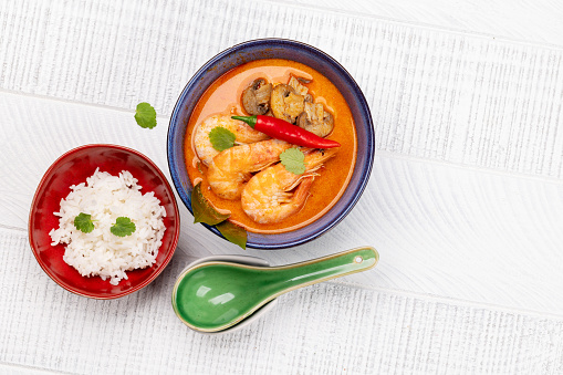 Thai Tom Yum Soup with seafood and bowl of rice. Flat lay with copy space
