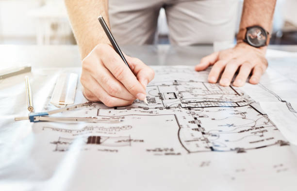 istock Drawing construction on blueprint, planning architecture design on paper and writing notes on building documents on table in work office. Designer, architect and builder with strategy for renovation 1449019407
