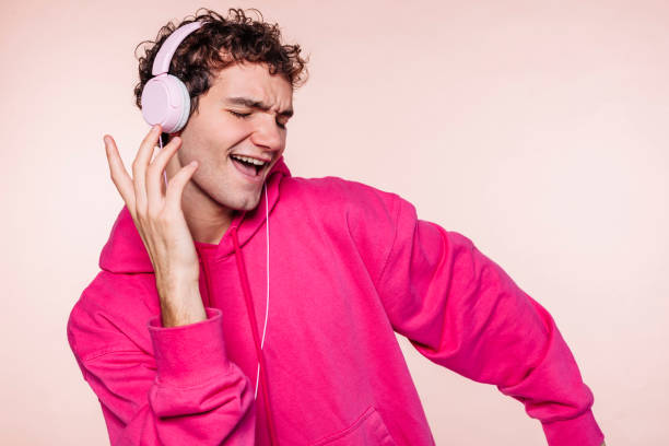 joven escucha música con auriculares y baila - contemporary style audio fotografías e imágenes de stock